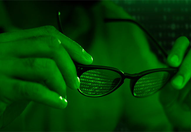 Hands holding glasses reflecting binary code, symbolizing digital surveillance, data privacy concerns, and the need for secure messaging.