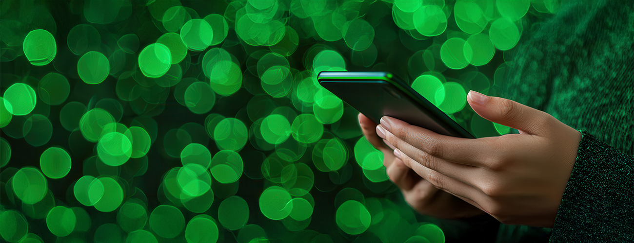 Close-up of hands holding a smartphone with a green bokeh background, symbolizing private messaging and secure communication.